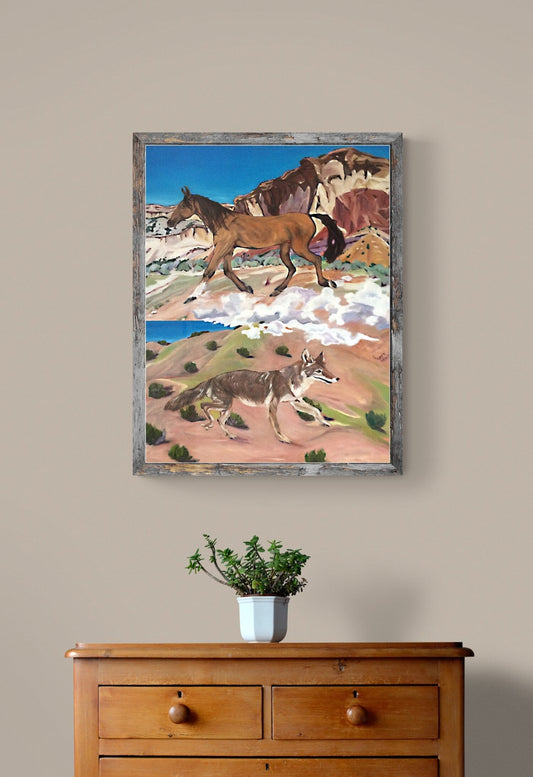 Framed Western horse and coyote painting staged above a wooden dresser with a plant.