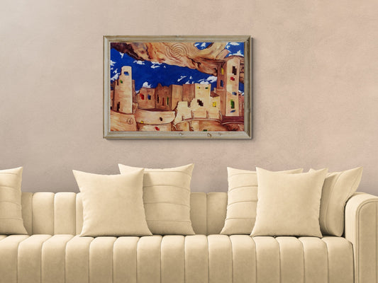 Surrealist Southwestern pueblo painting displayed framed on the wall.above a beige sofa for scale and size.